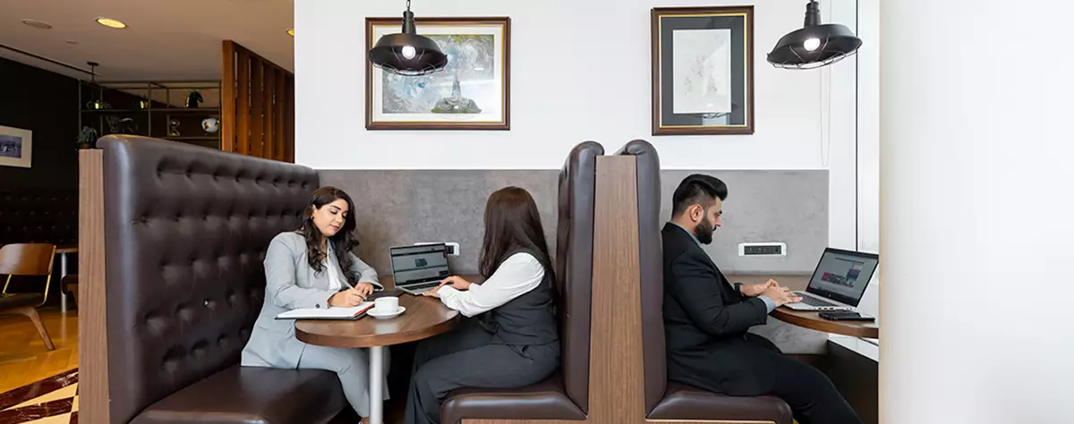 Booth seating in Emirates Towers, Dubai, were people are sitting working 
