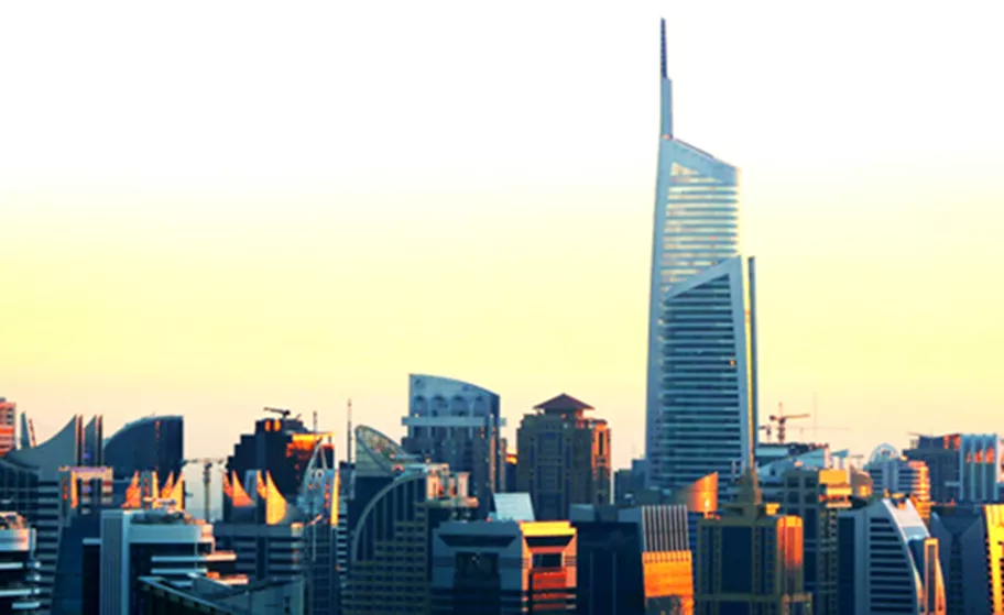 Tall modern skyscrapers at sunset, with Almas Tower standing prominently above the city skyline.